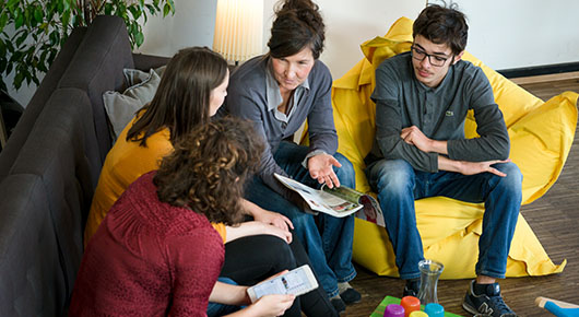 Vier Menschen besprechen sich in einer Sitzgruppe.